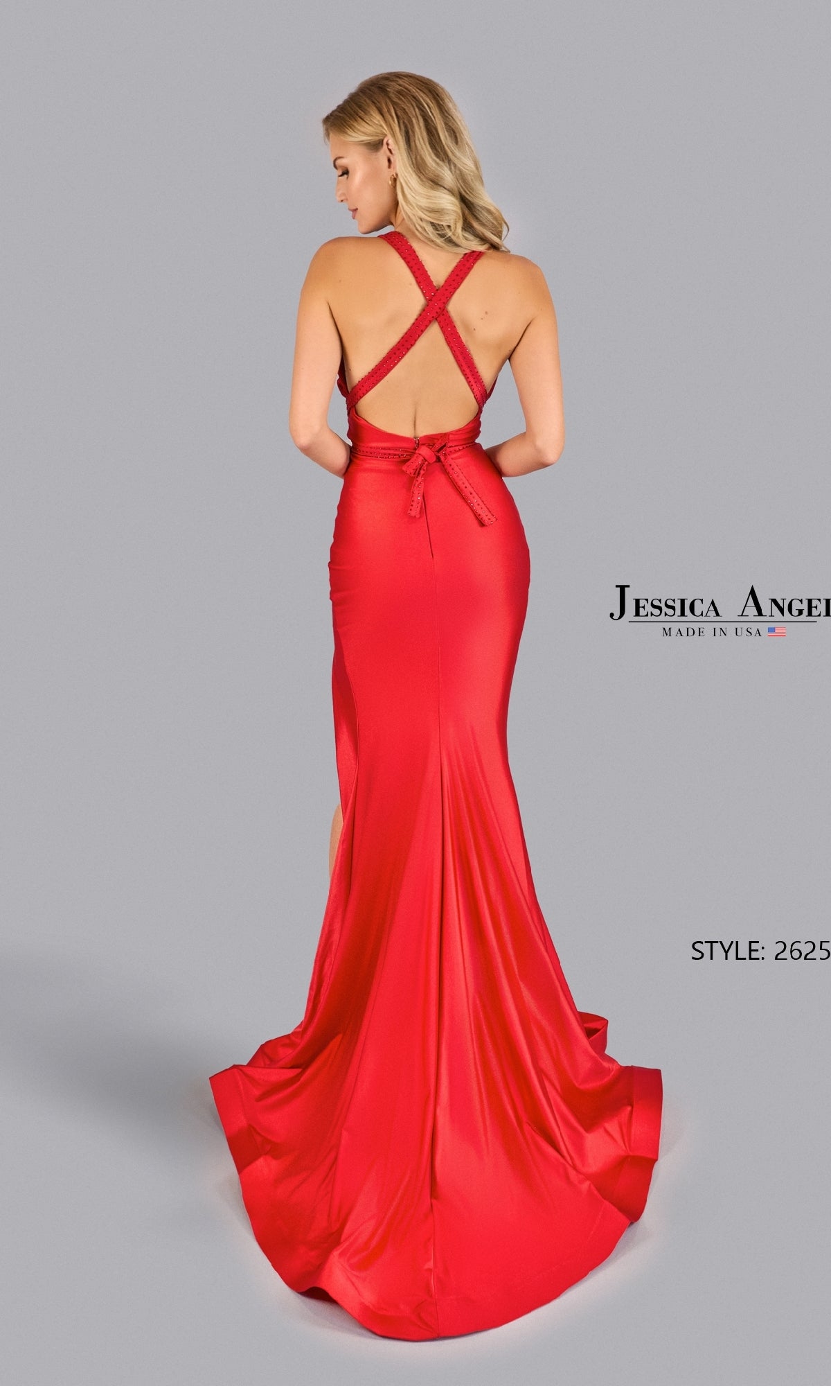 A woman wears the Jessica Angel 2625 Convertible Long Prom Dress, a floor-length bright red gown with a crisscross open back and fitted silhouette, posing against a plain gray background.